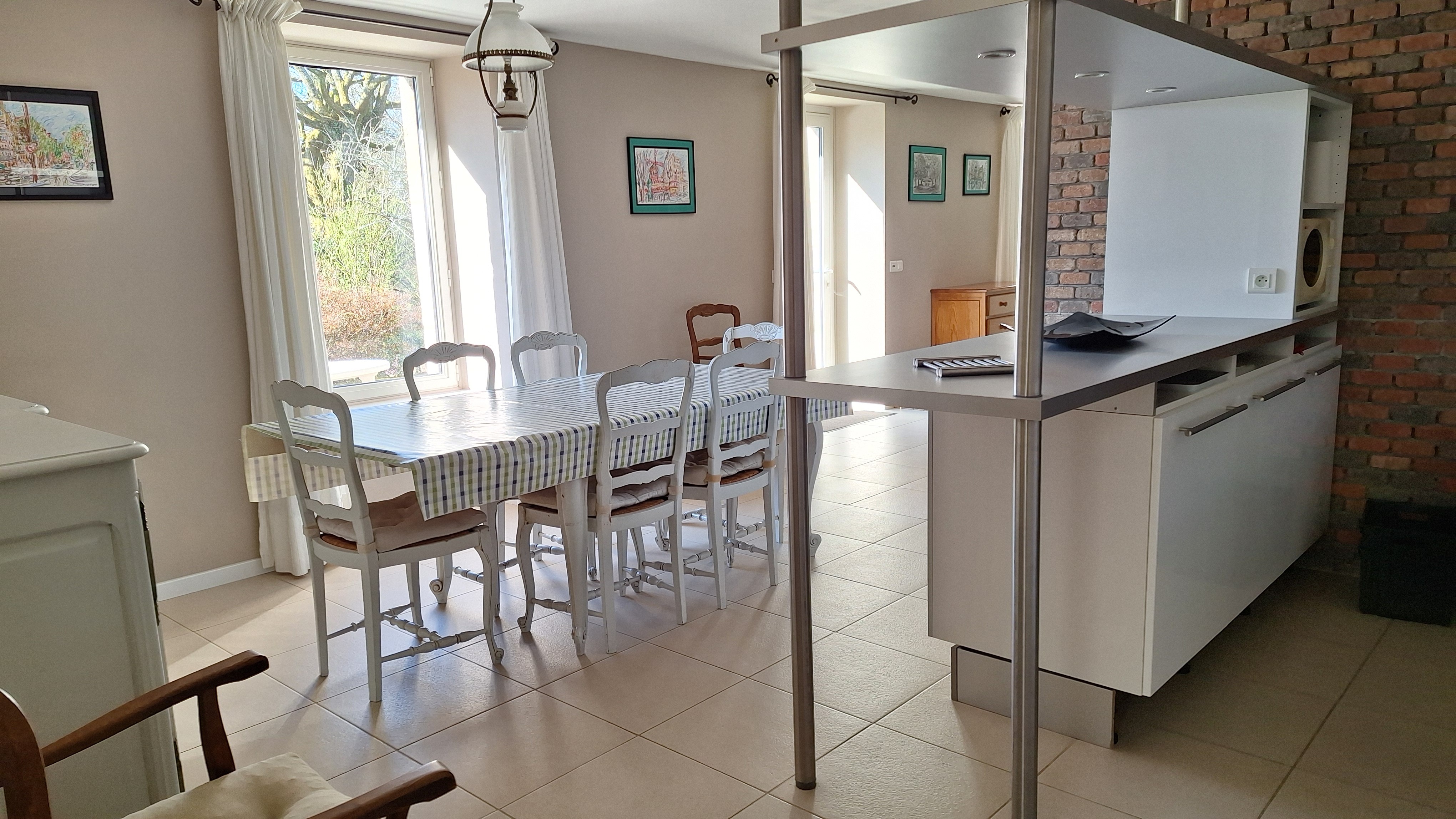 Salle-à-manger et plan-bar de la cuisine ouverte, donnant sur la terrasse, au sud/sud-ouest