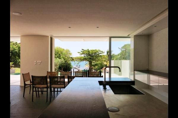 espace repas ouvert sur la terrasse avec une vue sur la piscine et la mer