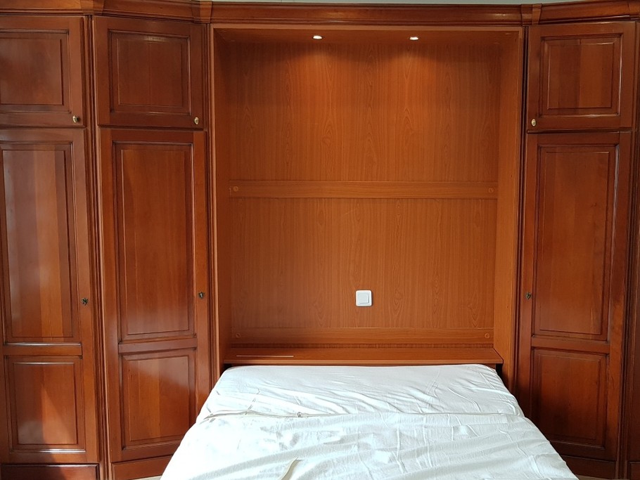 Le coin nuit est un lit confortable pour 2 personnes (140x190cm), élégamment dissimulé dans un dressing le jour.  
Crédits photos : Clévacances 35