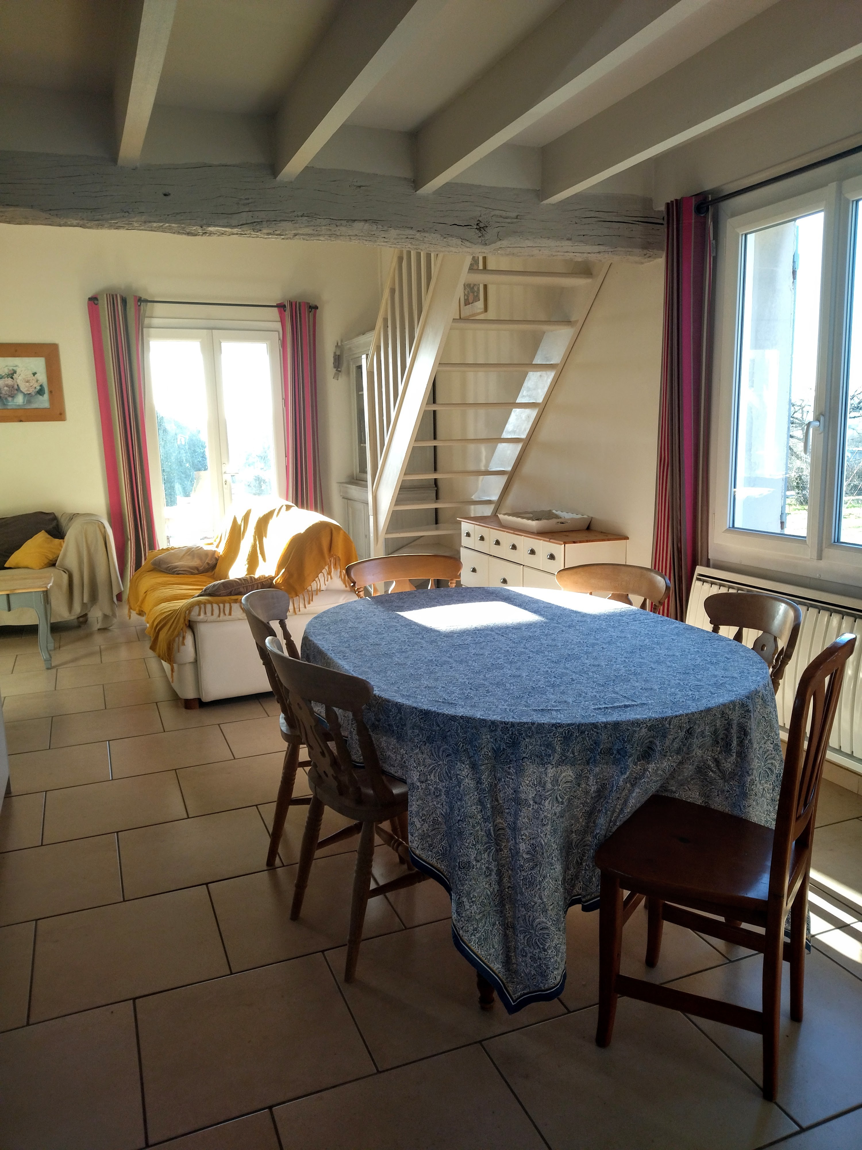 Partie salle à manger de la pièce de vie : au fond le salon donnant sur la terrasse  abritée côté piscine.