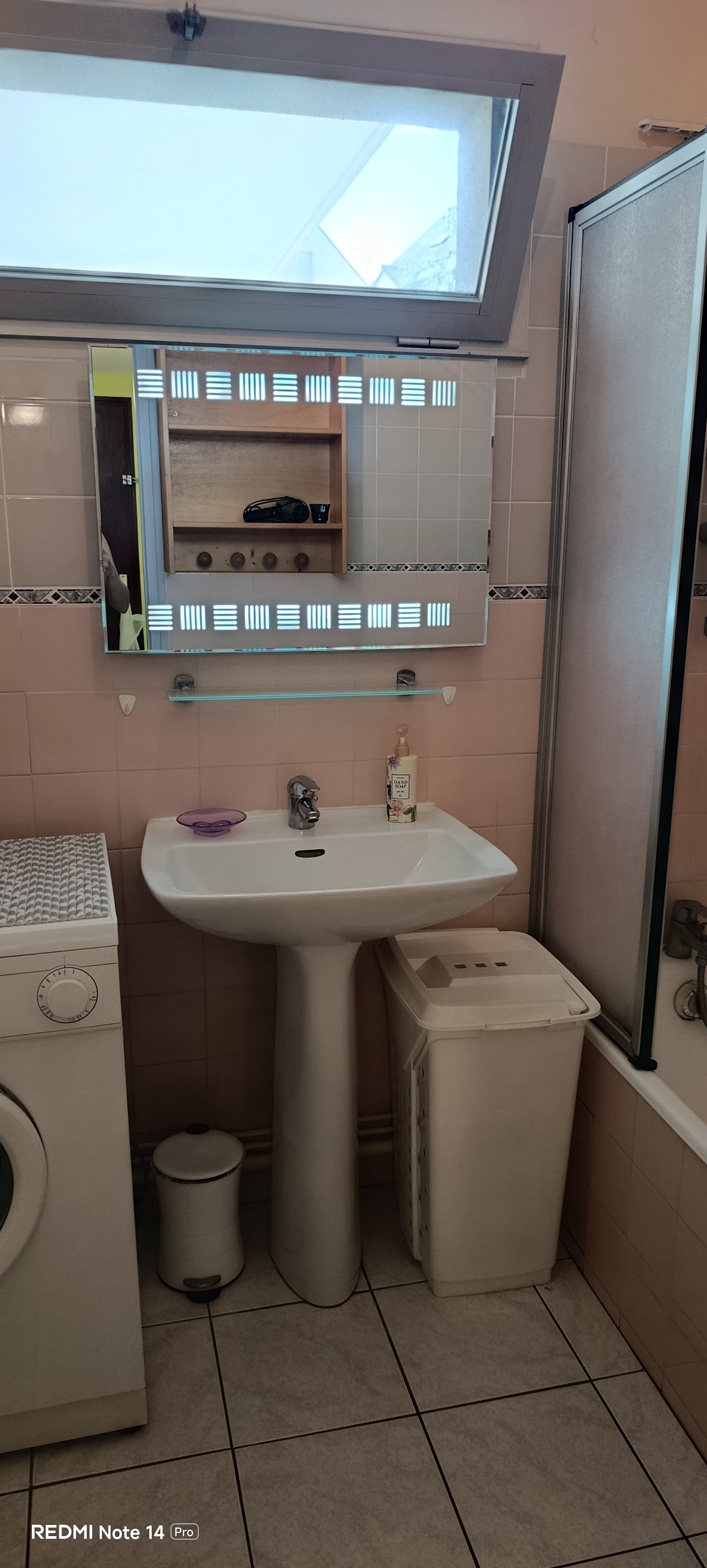 The bathroom with a bath, washing machine and storage shelves