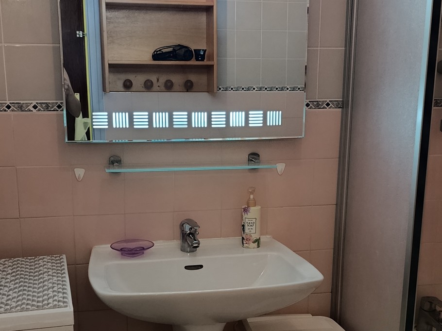 The bathroom with a bath, washing machine and storage shelves