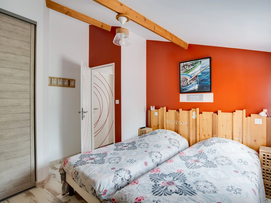 Chambre avec deux lits simple et écran plat.
