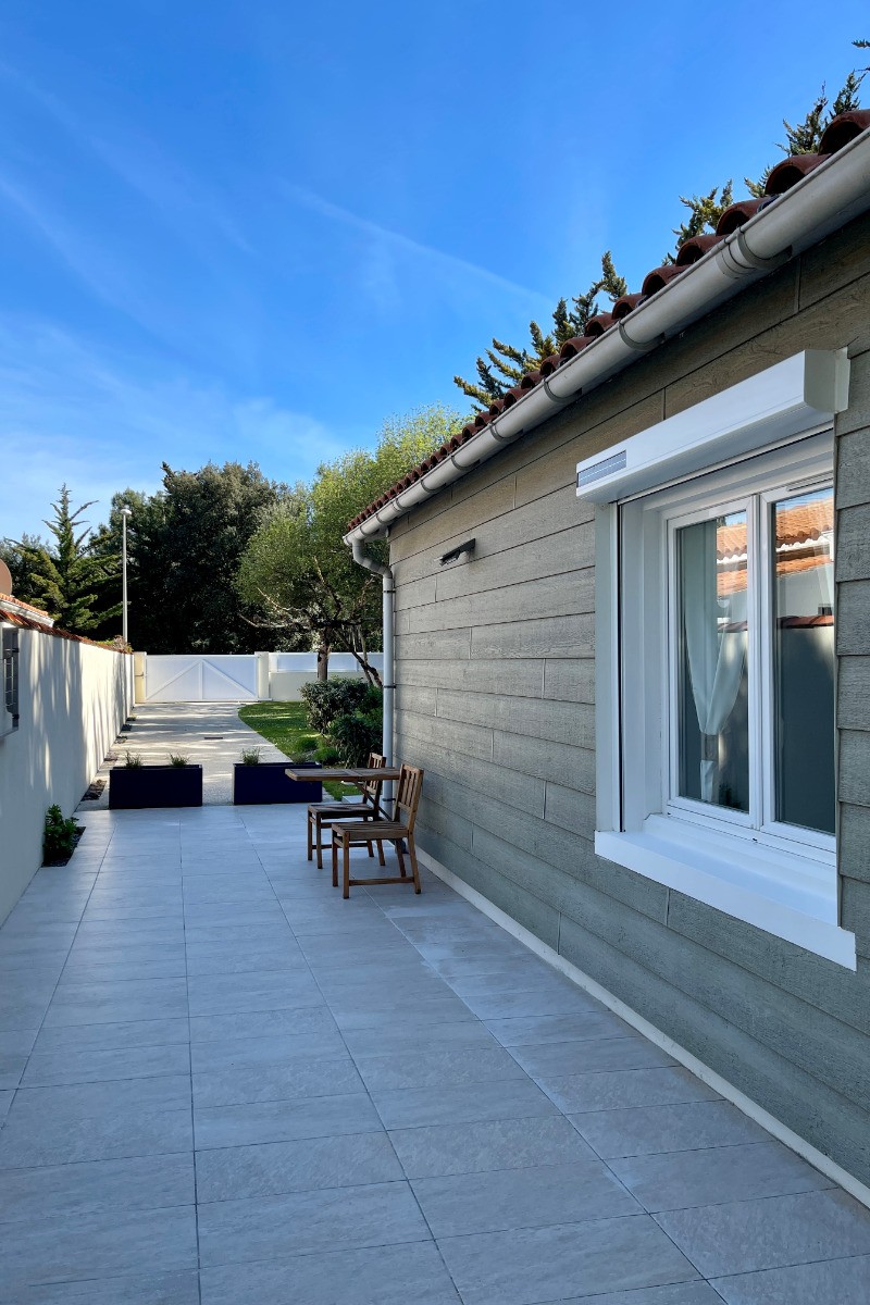 Vue sur le coté est de la maison, et fenêtre de la chambre n° 2 et entrée du jardin de 480 m2.
Parking pour 3 voitures.