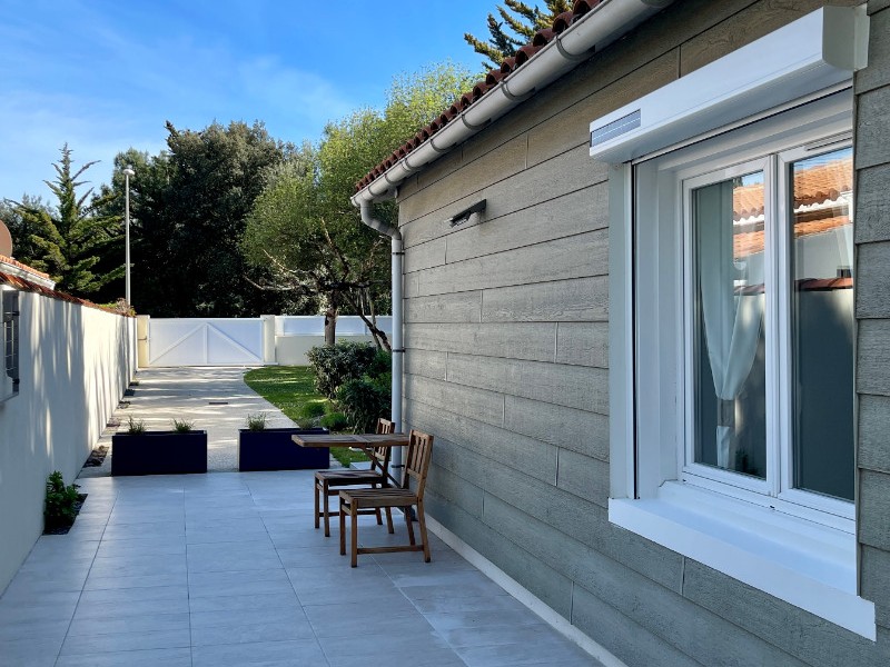 Vue sur le coté est de la maison, et fenêtre de la chambre n° 2 et entrée du jardin de 480 m2.
Parking pour 3 voitures.