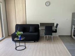 Coin repas avec cuisine aménagée et banquette de canapé.