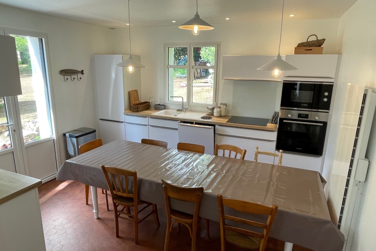 Cuisine ouverte équipée avec grande table pour 12 personnes