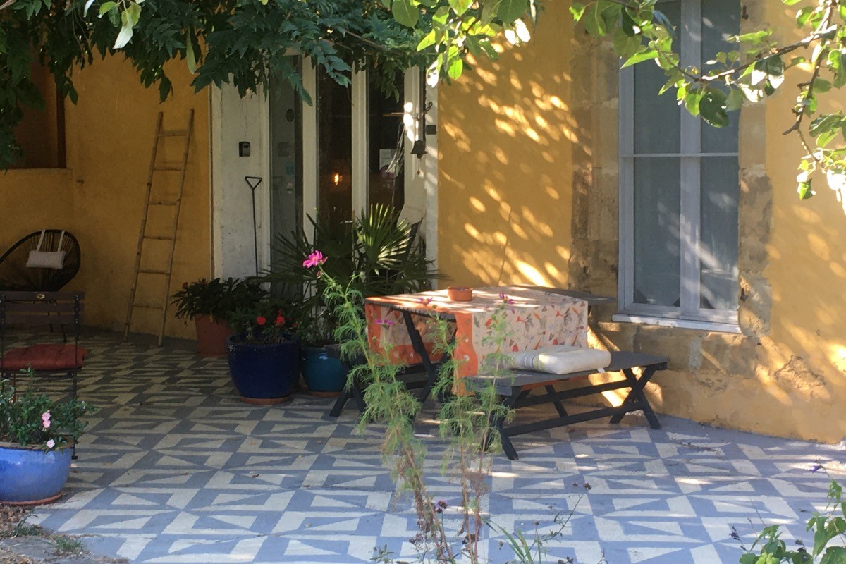 Terrasse avec vue de la piscine sous la glycine