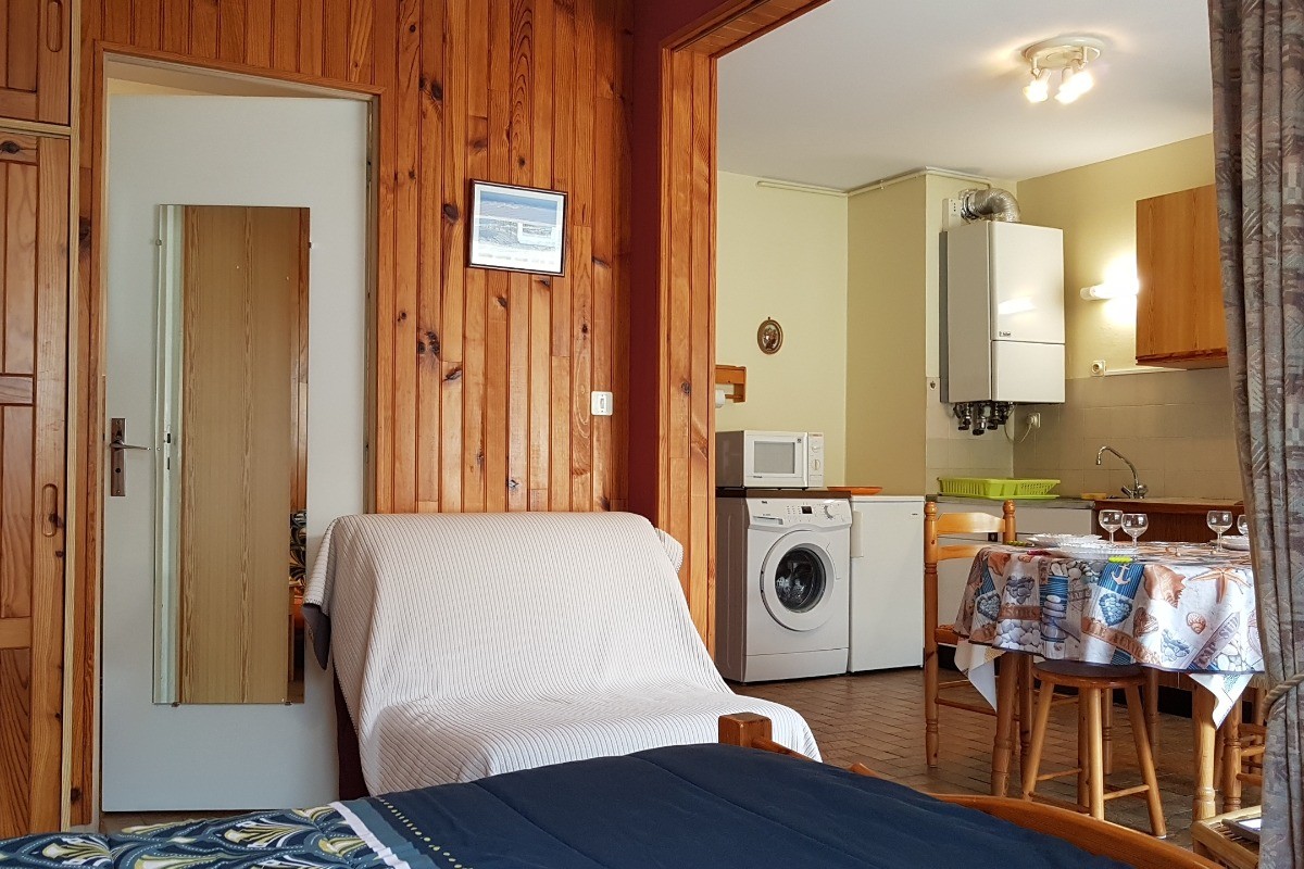 Depuis l'espace chambre, l'accès à la salle de bains-WC et à la salle-cuisine