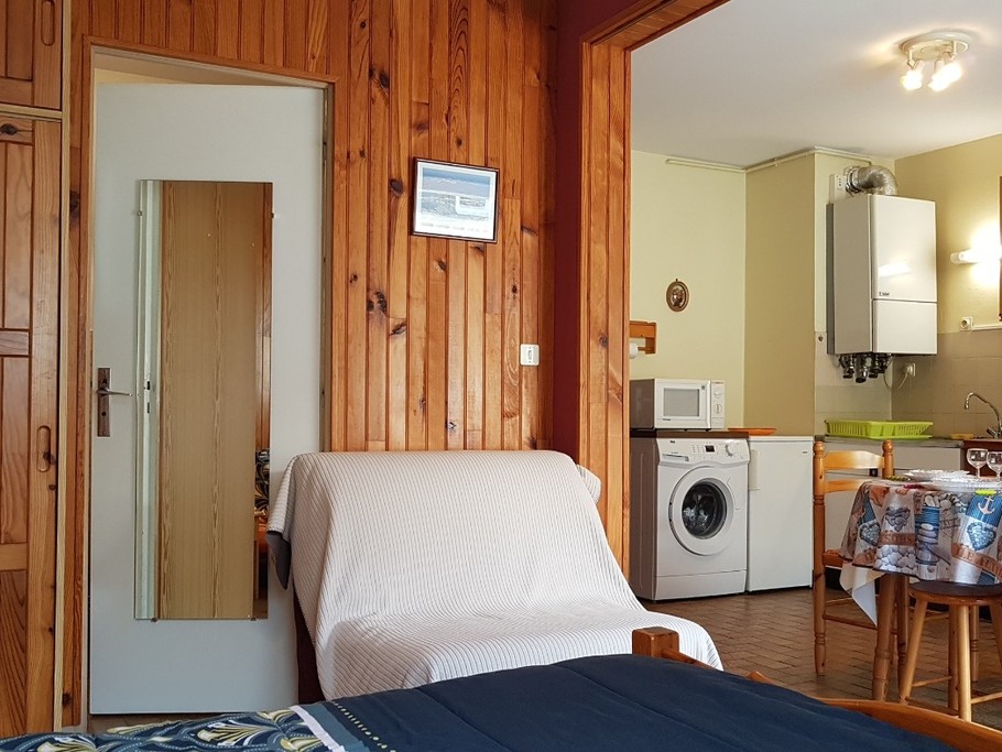 Depuis l'espace chambre, l'accès à la salle de bains-WC et à la salle-cuisine