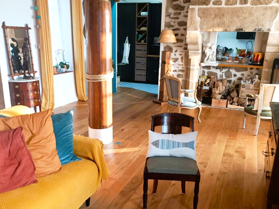 Grande pièce de vie avec 2 salons, un poêle à bois, un séjour dans la véranda vue mer.