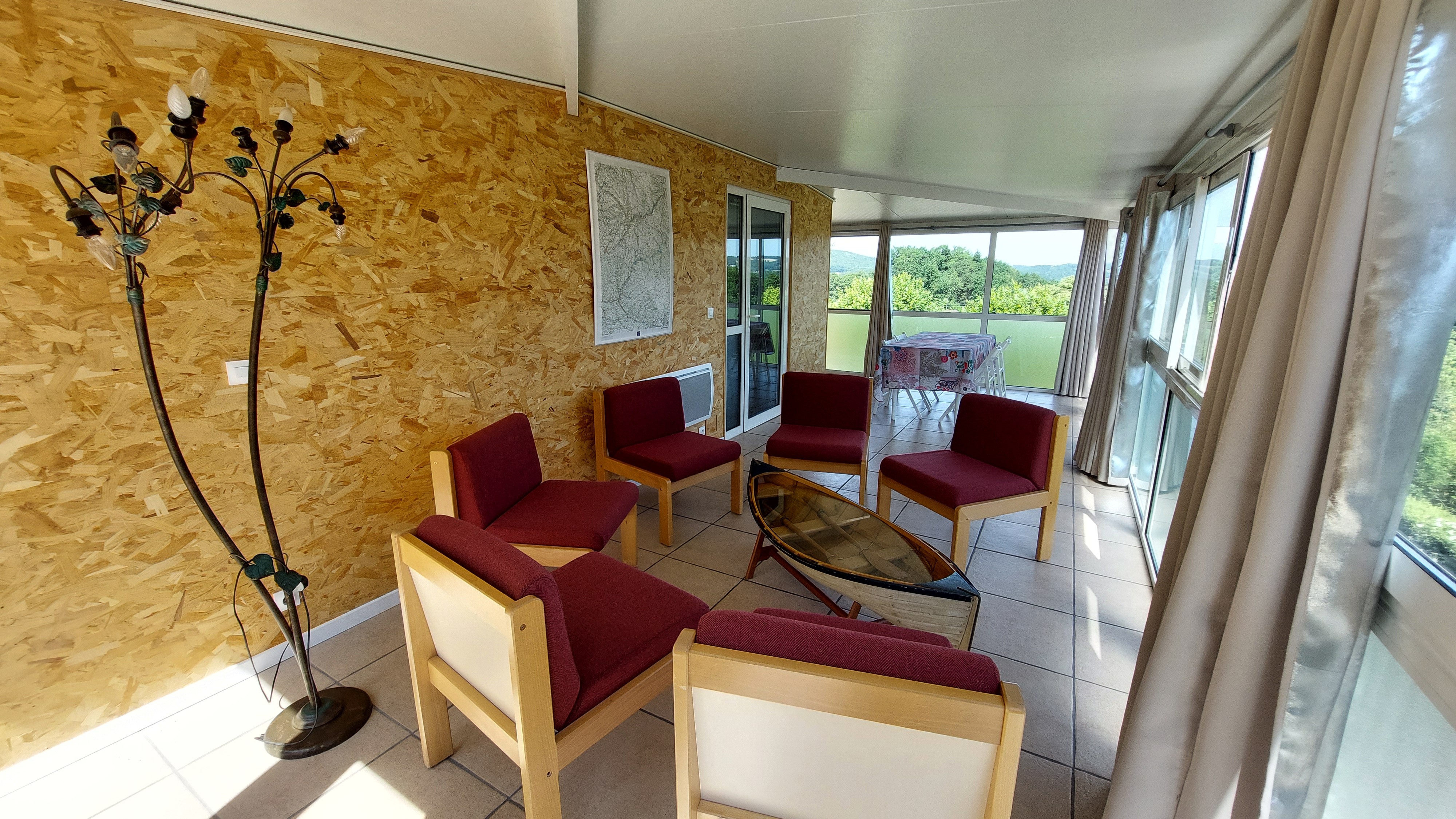 Salon dans la véranda du gîte Lilas avec vue sur le Cantal