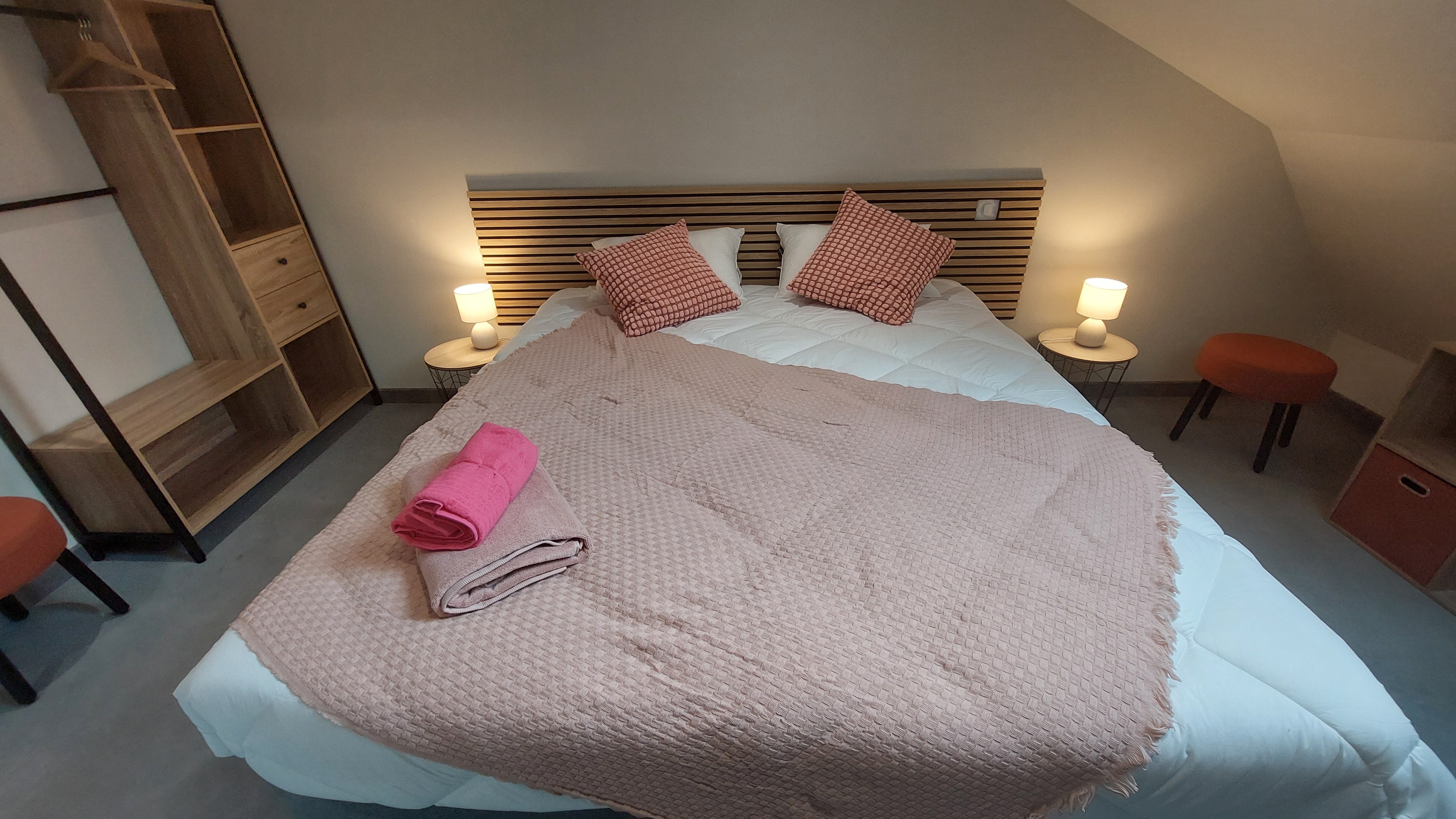 Deuxième vue de la chambre rose avec espace de rangement et décoration cosy