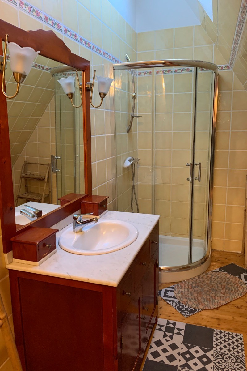 Salle d'eau à l'étage avec douche d'angle, meuble vasque et WC.