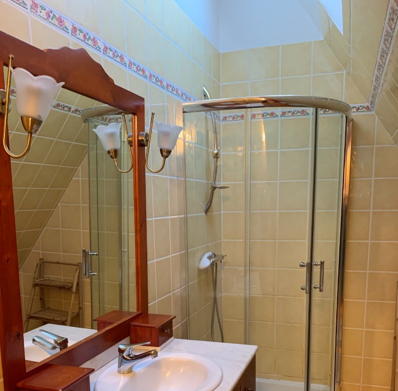 Salle d'eau à l'étage avec douche d'angle, meuble vasque et WC.