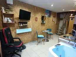 Living area with massage and pressotherapy chair, sauna and whirlpool bath, kitchen and dining area.