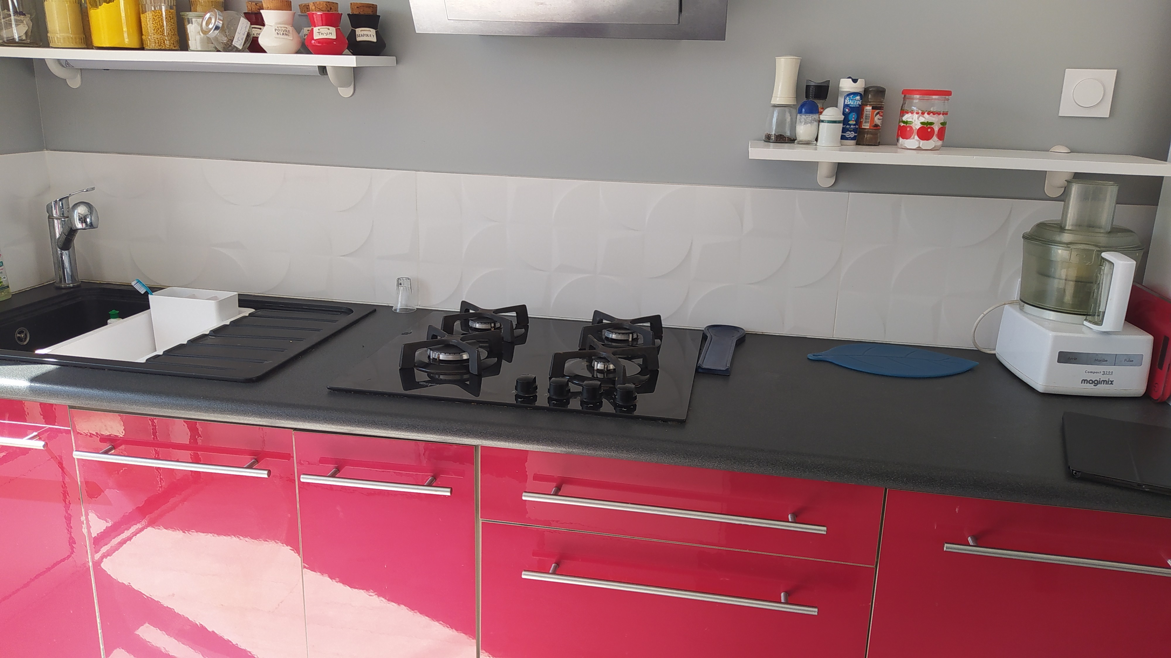 Pièce de vie au RDC avec entrée, cuisine, séjour, salon et poêle à bois.