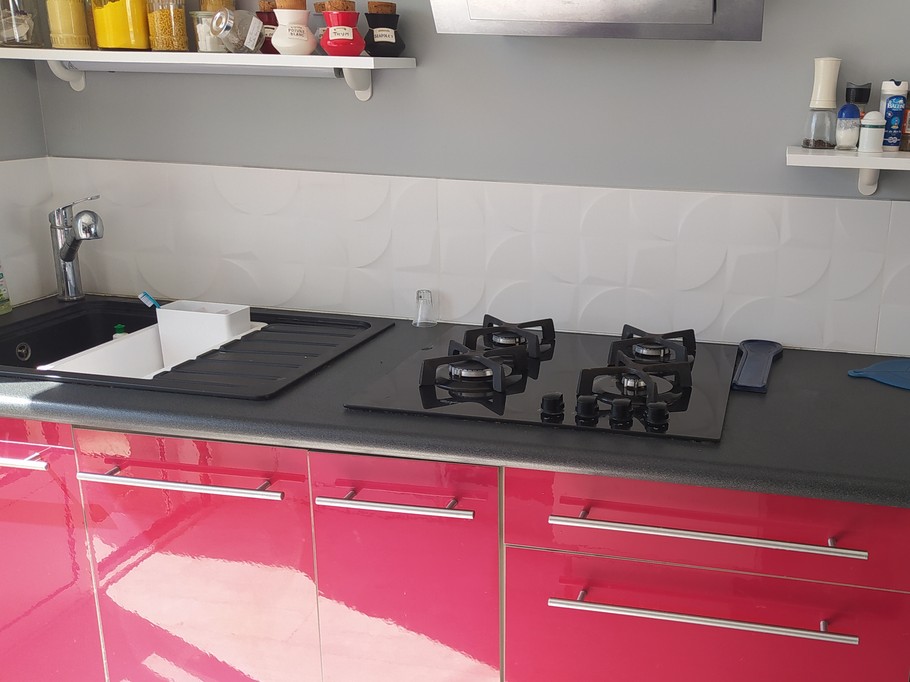 Pièce de vie au RDC avec entrée, cuisine, séjour, salon et poêle à bois.