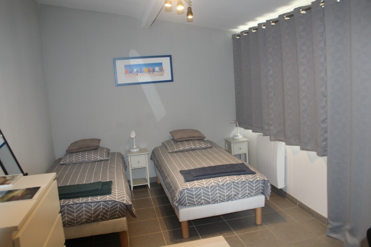 chambre du bas avec  accès direct au jardin, 2 lits 90x190  jumelables avec surmatelas.  chambre/ bureau avec rideaux occultants et TV.