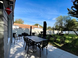 Vue sur le jardin de 480 m2, depuis la terrasse, et l'entrée de la villa.