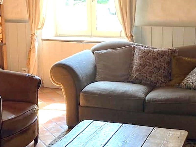 Grand salon chaleureux avec poutres apparentes et cheminée d'apparat.
Crédits photo : Mégane ARNAL