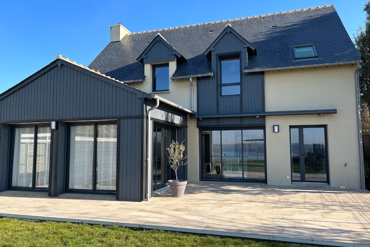 Façade arrière de la maison, avec grande terrasse et accès au jardin vue Rance. A la belle saison, possibilité de prendre le petit-déjeuner sur la terrasse et transats à votre disposition.