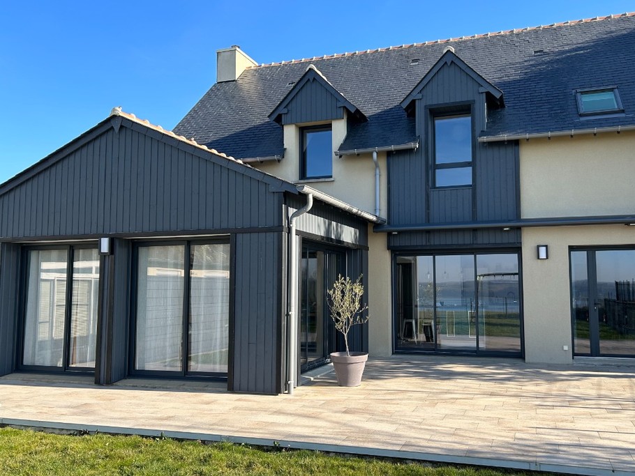 Façade arrière de la maison, avec grande terrasse et accès au jardin vue Rance. A la belle saison, possibilité de prendre le petit-déjeuner sur la terrasse et transats à votre disposition.