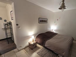 Chambre aménagée avec un lit de 1,80 m et entrée de la salle de bain