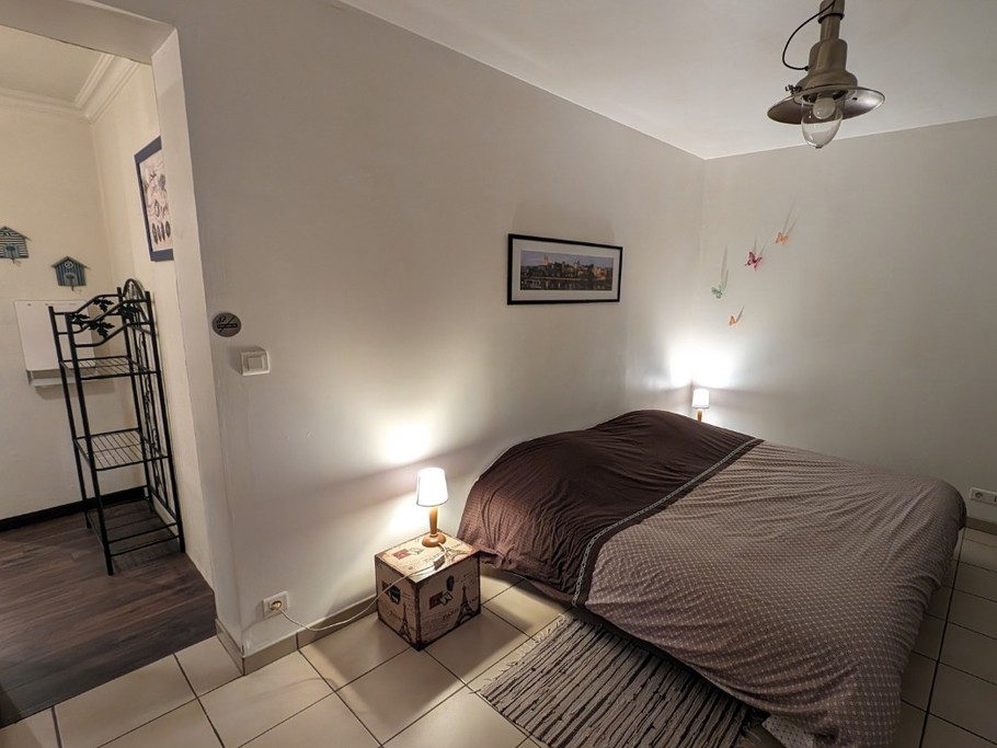 Chambre aménagée avec un lit de 1,80 m et entrée de la salle de bain