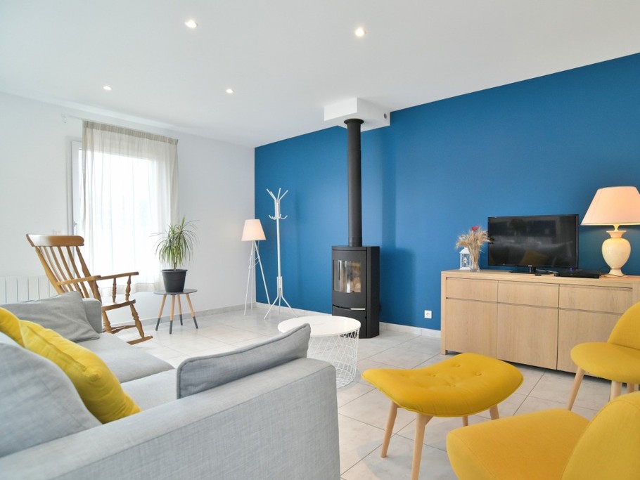 Grande pièce de vie avec coin cuisine, coin séjour et coin salon avec poêle à bois.