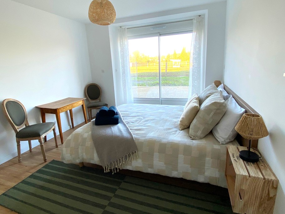 Chambre 1 au RDC de plain pied avec lit 160 cm et rangements. Salle d'eau communicante. WC séparé.