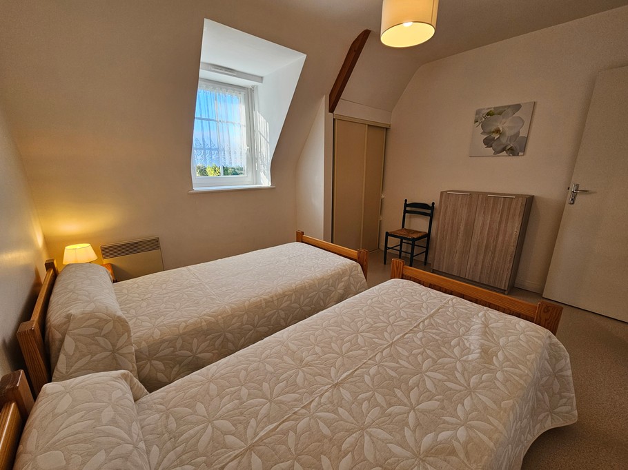 Chambre indépendante pour 2 personnes avec 2 lits 90x190 cm, commode, armoire et chaise.