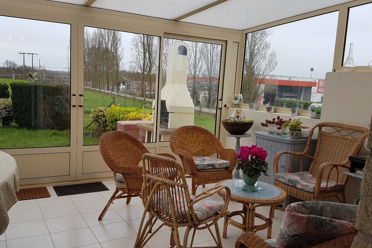 Le salon de la véranda avec accès au jardin et à la terrasse