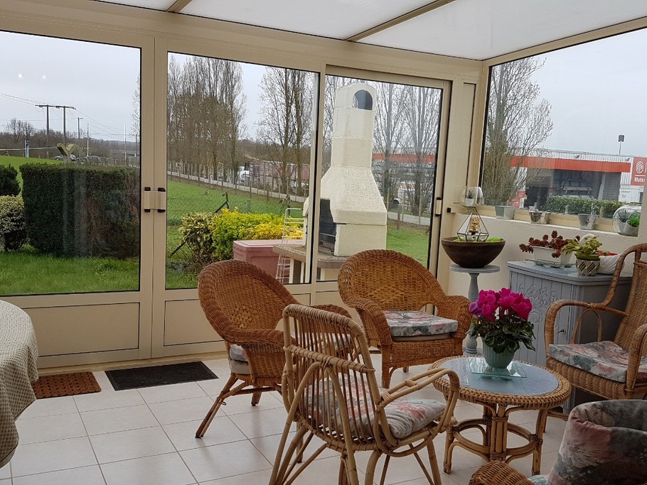 Le salon de la véranda avec accès au jardin et à la terrasse