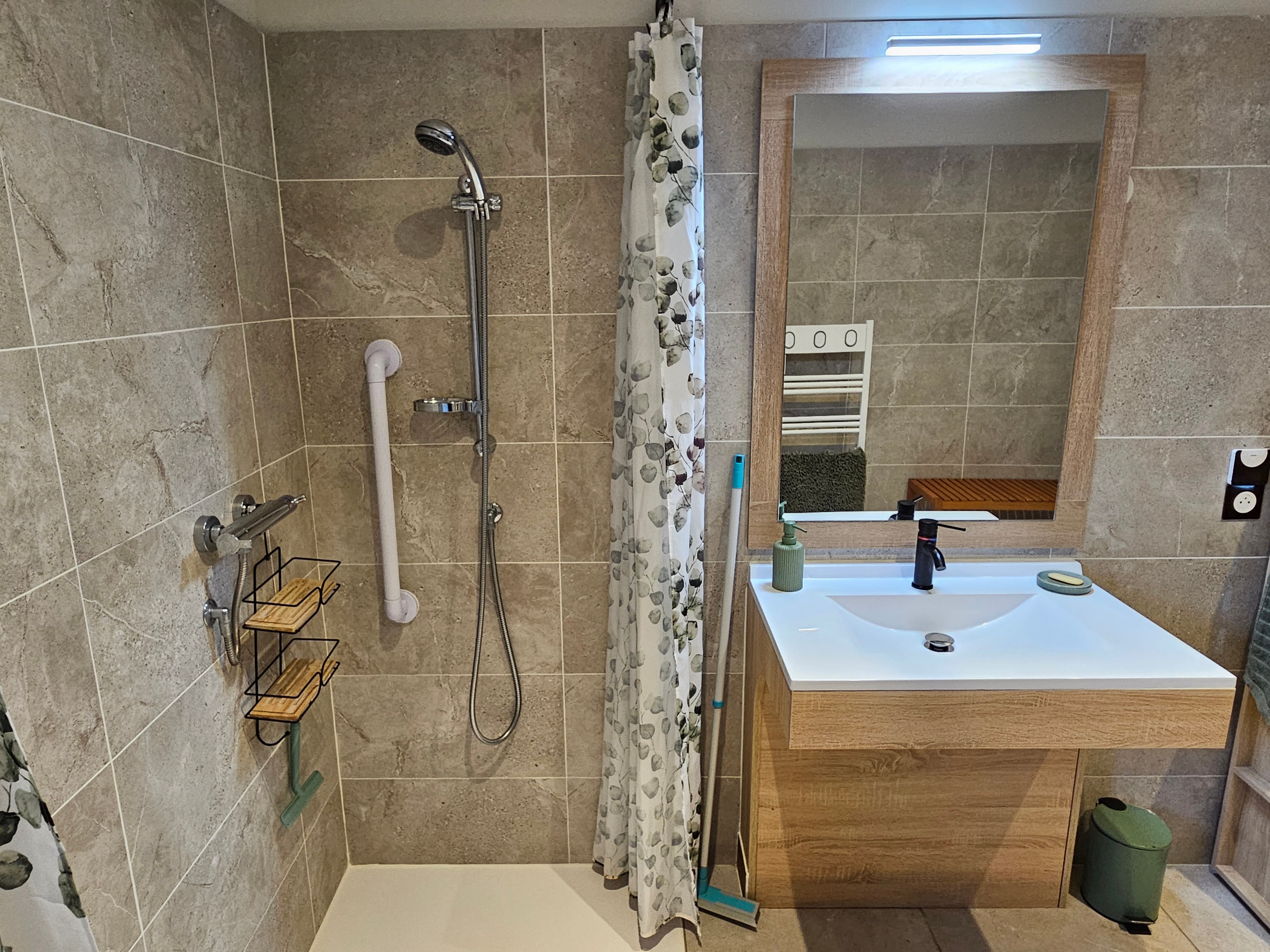 Accessible bathroom with a large shower, toilet and heated towel rail.