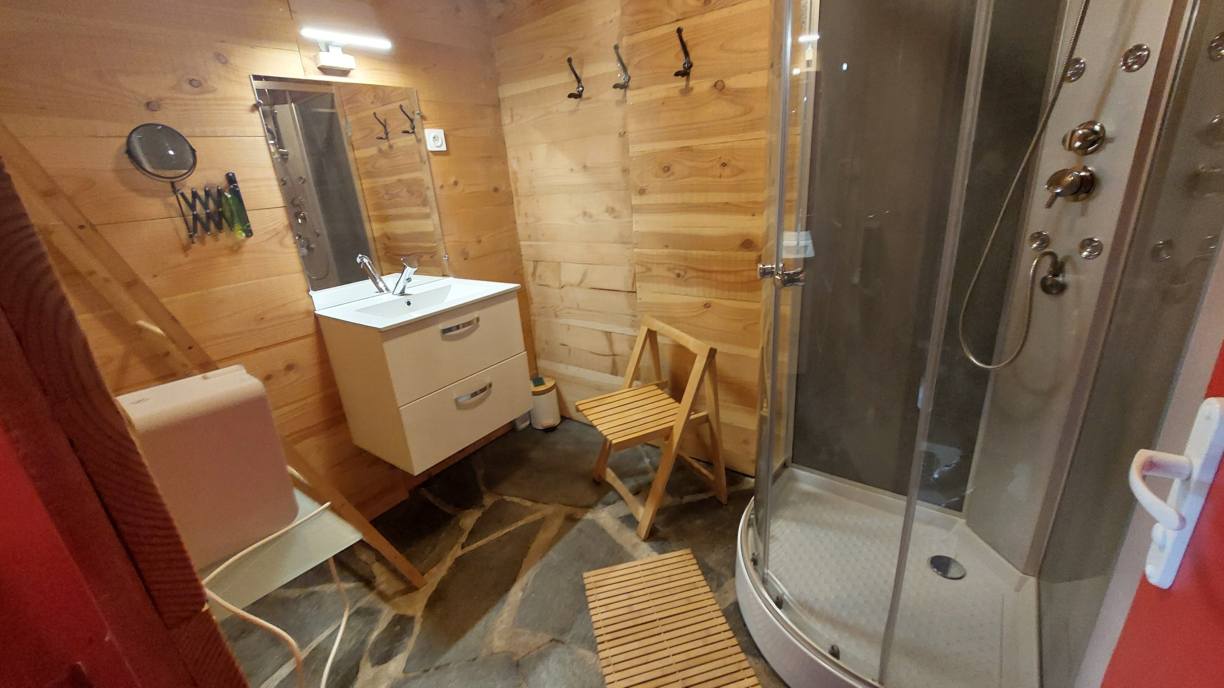 Salle d’eau indépendante avec douche et lavabo, située dans le bâtiment annexe du gîte