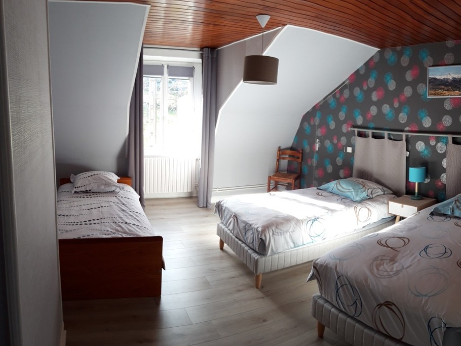 Chambre spacieuse avec trois lits simples, idéale pour les enfants ou amis.