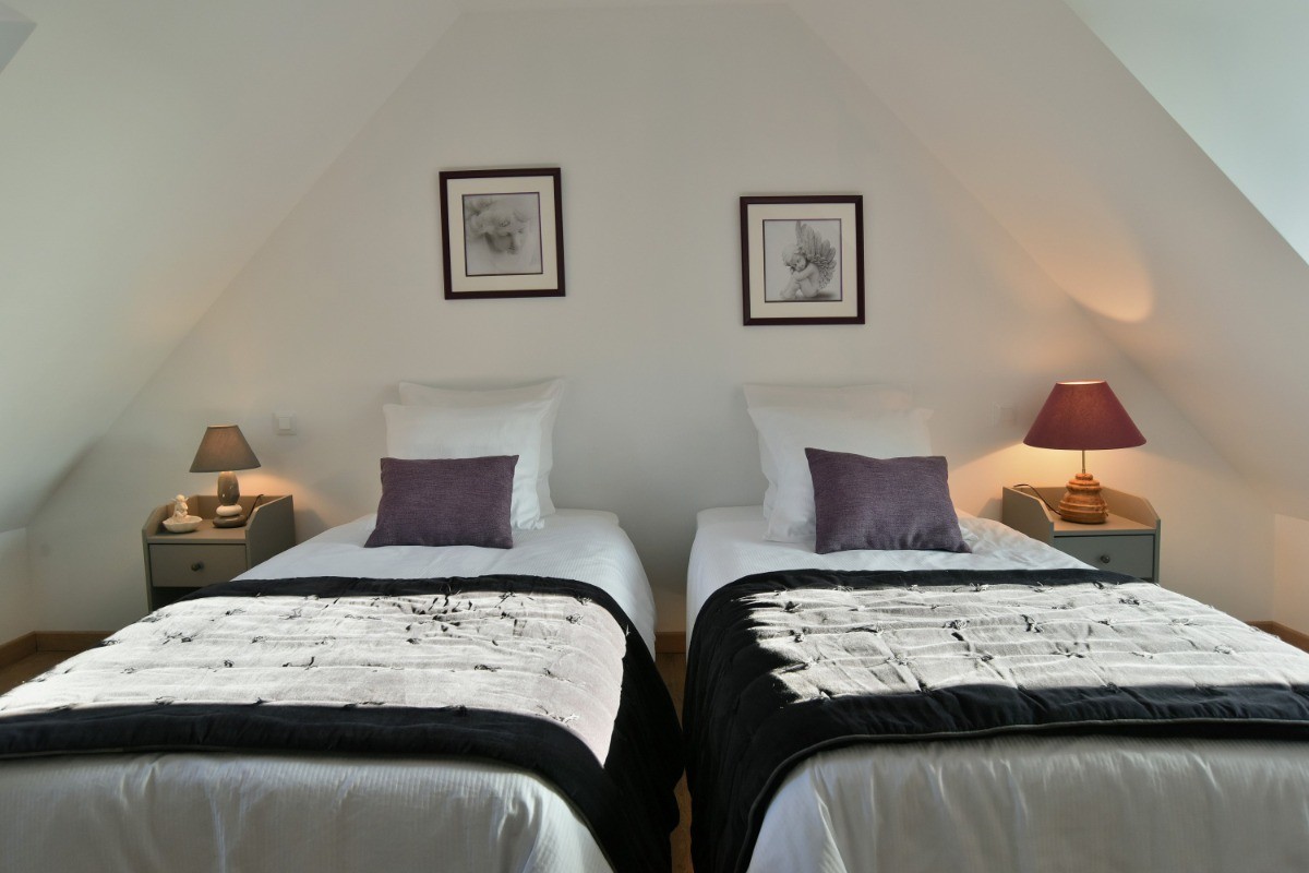 1 chambre mansardée pour 2 personnes au 2nd étage (avec deux lits individuels très confort 100x200 cm). Salle d'eau, WC séparés et coin bureau au même étage.