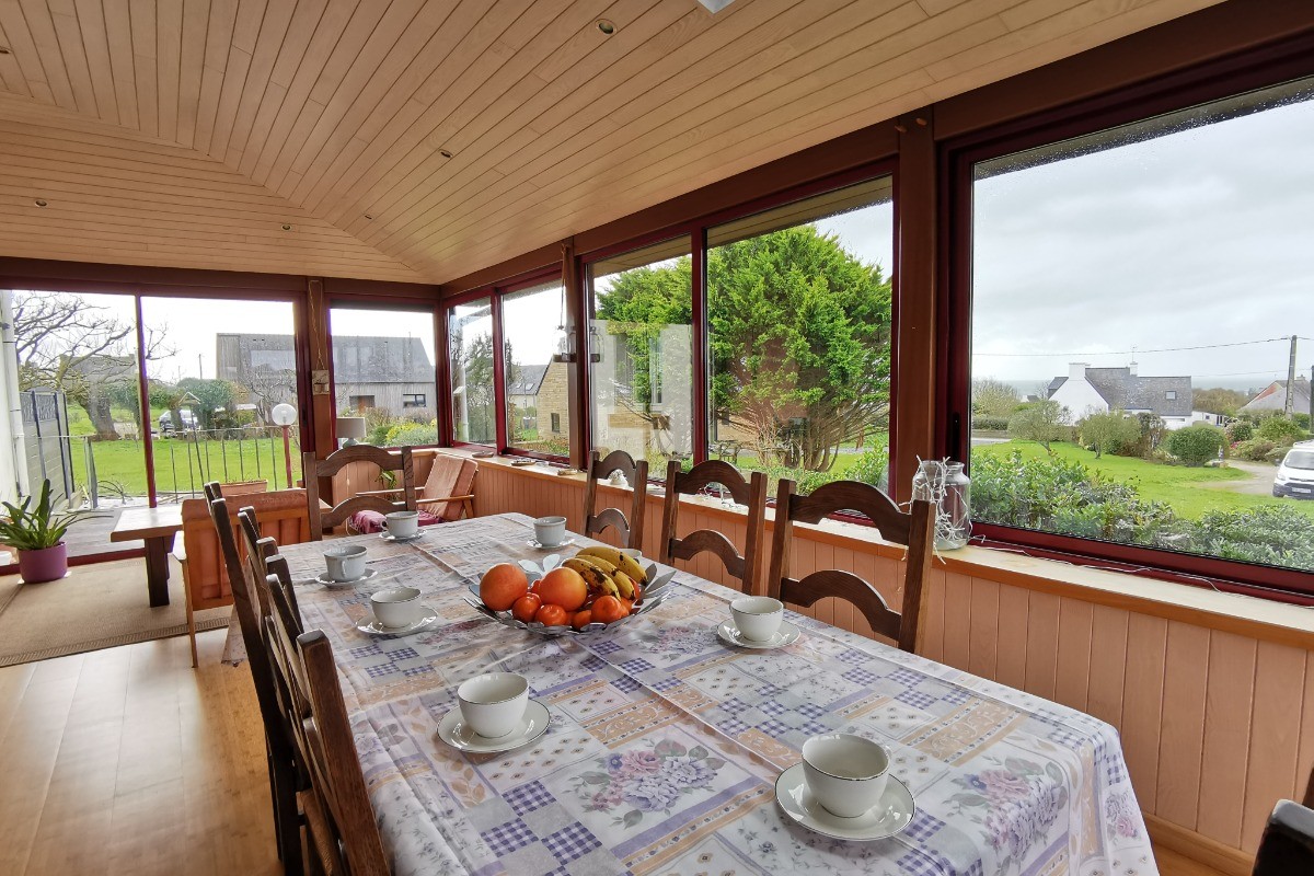 Espace petit déjeuner dans la véranda et vue sur mer et le jardin