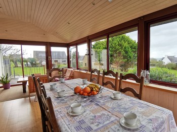 Espace petit déjeuner dans la véranda et vue sur mer et le jardin