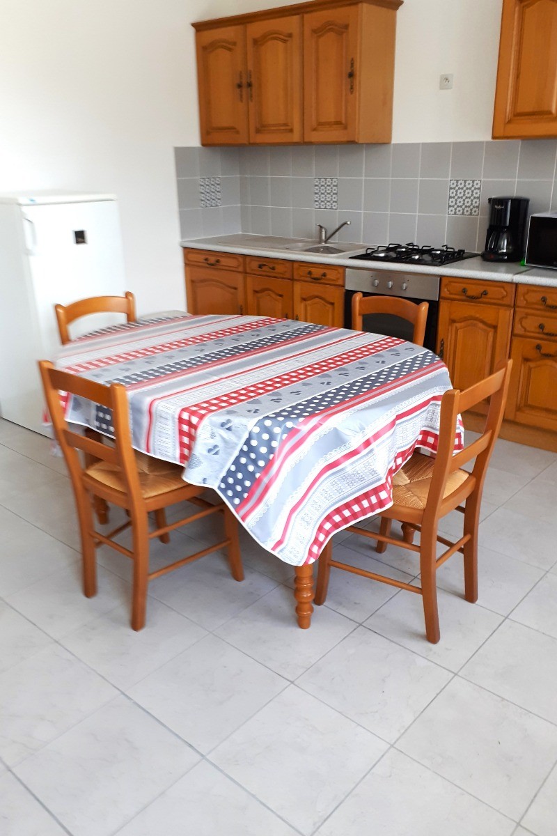 Pièce de vie avec une cuisine équipée (four, micro-ondes, plaques gaz, combiné congélation, etc), une table pour vos repas et une TV.