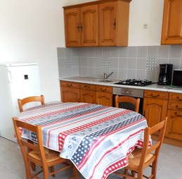 Pièce de vie avec une cuisine équipée (four, micro-ondes, plaques gaz, combiné congélation, etc), une table pour vos repas et une TV.