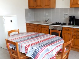 Living room with fully-equipped kitchen (oven, microwave, gas hob, freezer, etc.), dining table and TV.