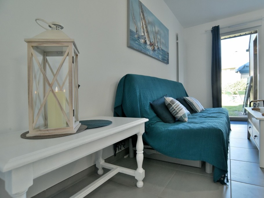 Pièce de vie lumineuse au RDC avec coin salon et TV.