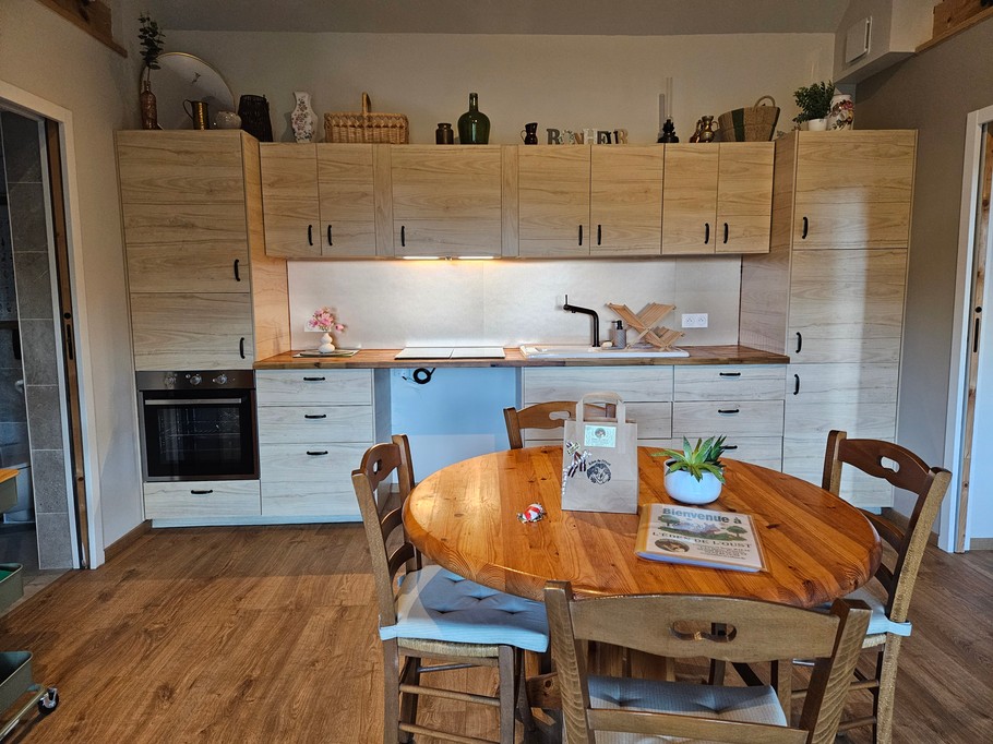Open-plan living area with fitted kitchen, lounge and dining table.