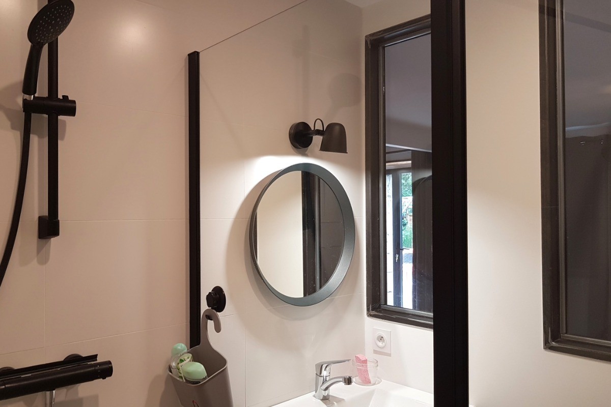 Salle d'eau communicante avec douche à l'italienne grande dimension, meuble vasque et rangements.