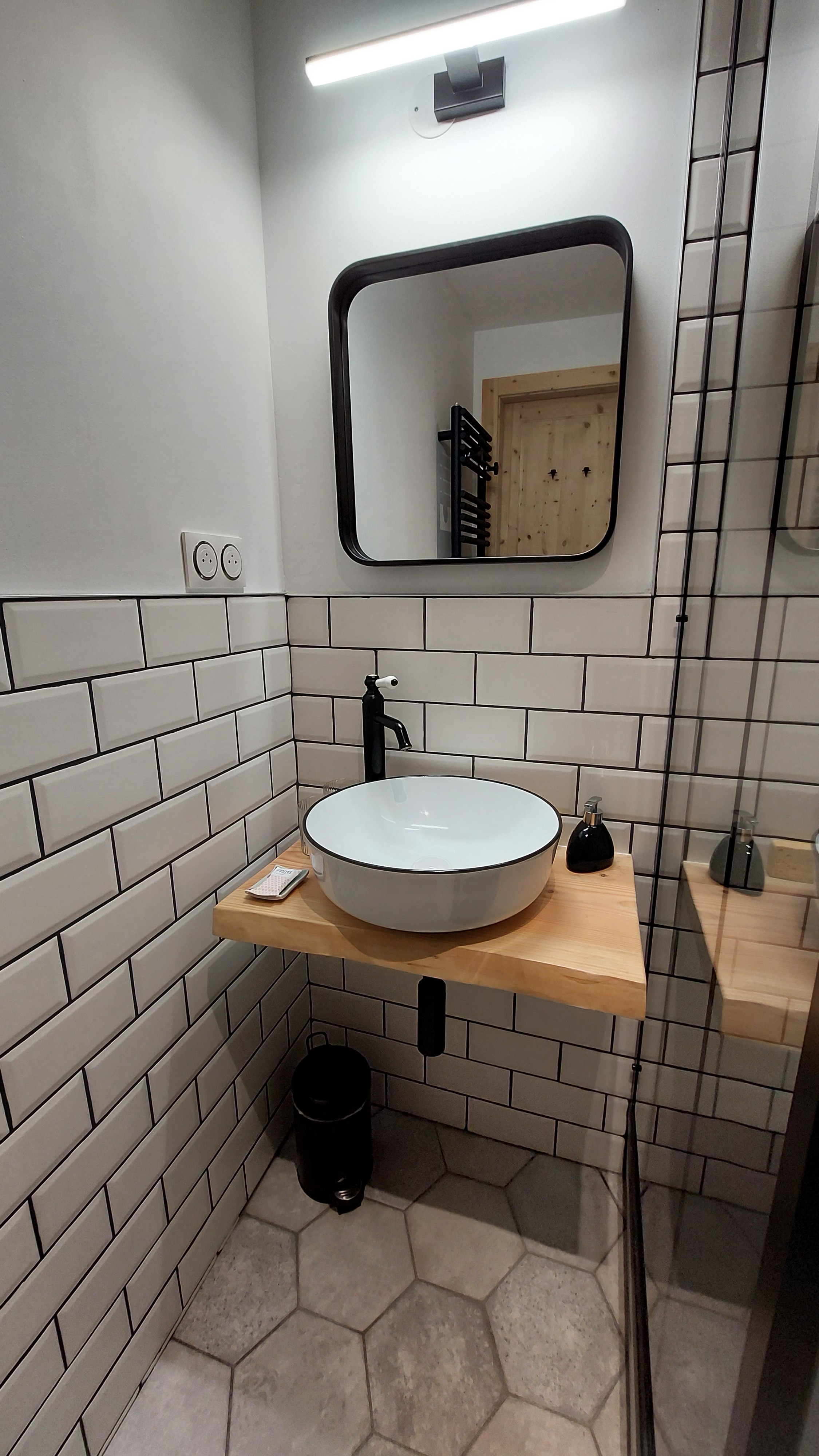 White washbasin on solid wood furniture in a contemporary bathroom in Marchastel