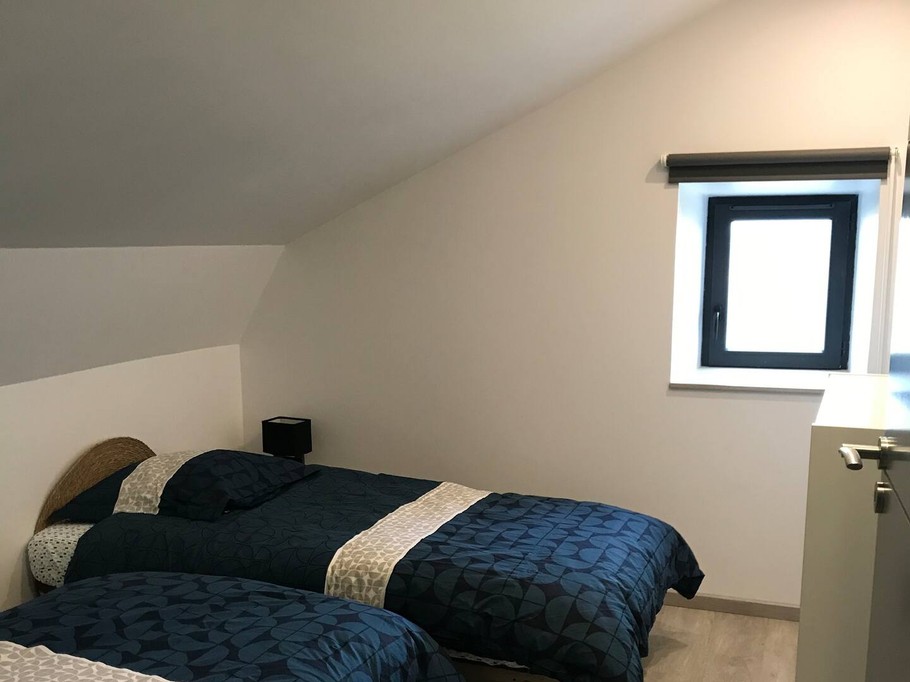 Chambre lumineuse avec deux lits simples, idéale pour enfants ou amis.