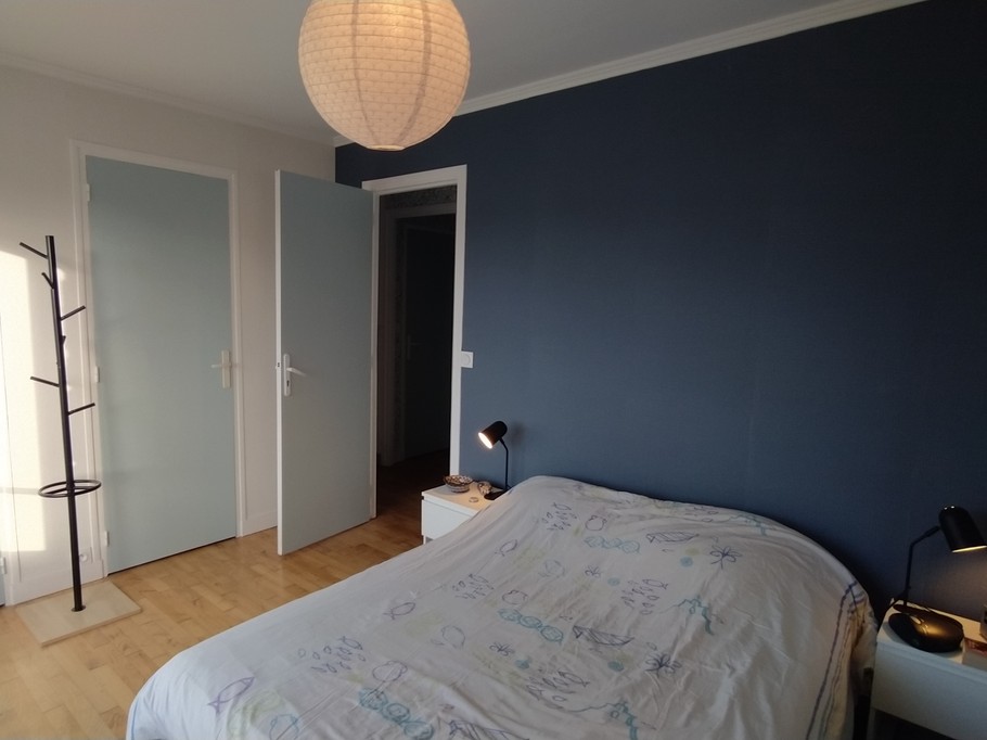 Chambre 1 avec un lit 140 cm, rangements, porte-manteau, et salle d'eau communicante (douche grande dimension et meuble vasque avec miroir)