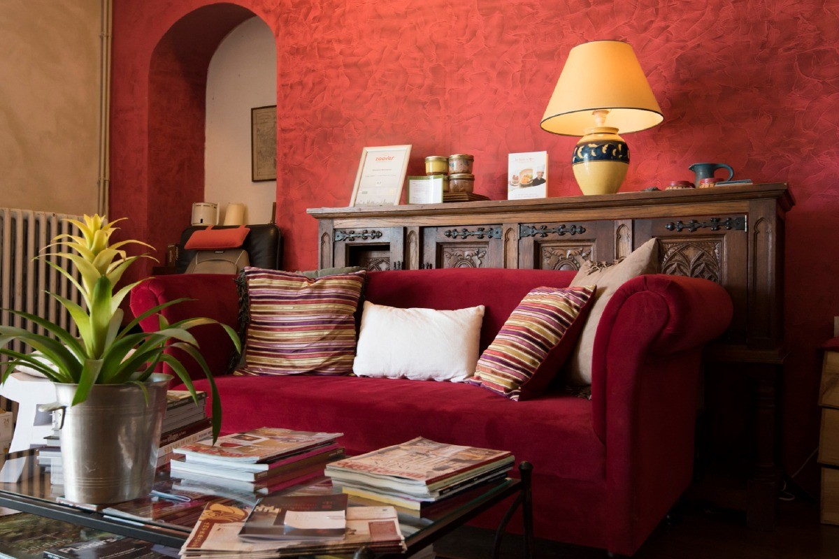 Salon Rouge avec canapé et petite librairy, salon with seating area and small library